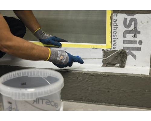 Anwendung von Dichtmasse mit einer Farbwalze in einem Badezimmer