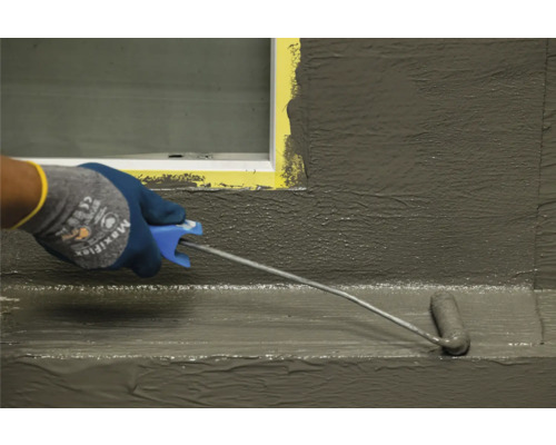 Auftragen einer Abdichtung mit einer Farbrolle auf eine Oberfläche.