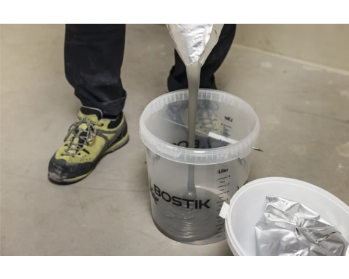 Fließspachtel wird in einen Eimer gegossen