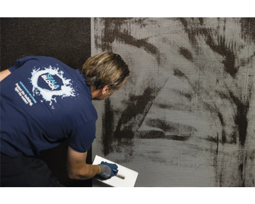 Anwendung von Dichtungsschlämme auf einer Wand mit einer Kelle