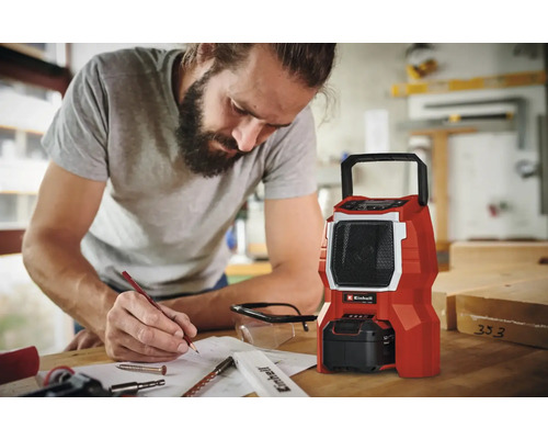 Ein Mann plant neben einem roten Einhell Baustellenradio ein Projekt