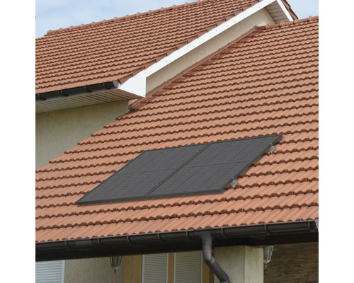 Auf einem Dach mit Ziegeln sind Solarmodule montiert.