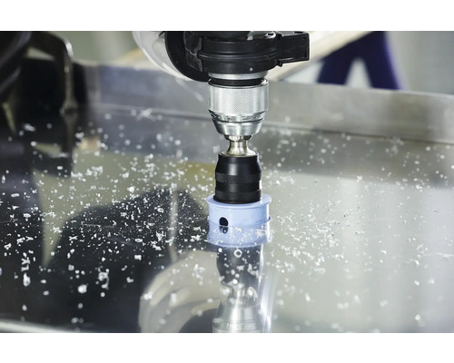 Lochsäge bohrt ein Loch in eine Metallplatte