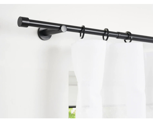 Gardinenstange mit Vorhangringen und weißem Vorhang an der Wand