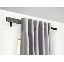 Gardinenstange mit grauen Vorhängen an der Wand