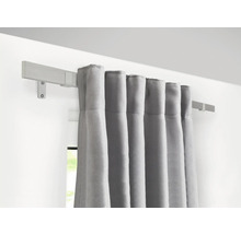 Graue Vorhänge hängen an einer Holzgardinenstange an der Wand