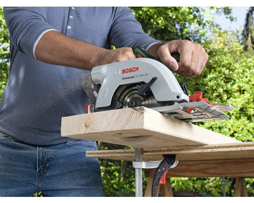 Eine Person sägt ein Holzbrett mit einer Bosch Handkreissäge.