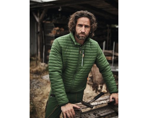 Mann mit Arbeitskleidung und Steppjacke im Freien