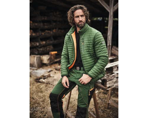Mann trägt grüne Arbeitskleidung, bestehend aus Jacke und Hose