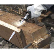 Handsäge schneidet Holzbalken