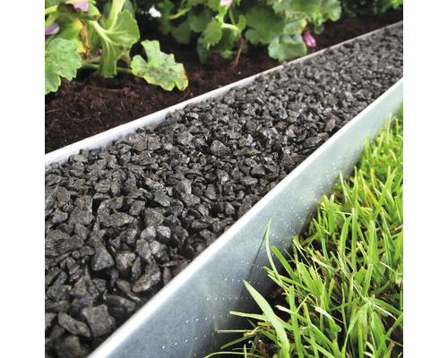 Garten mit Rasen, Pflanzen und Metallbeeteinfassung gefüllt mit Zierkies