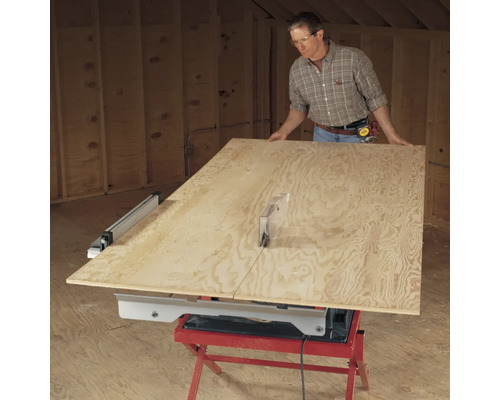 Mann schneidet Holzplatte mit einer Tischkreissäge.