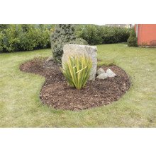 Gestalteter Gartenbereich mit Pflanzen, Steinen und Rasen