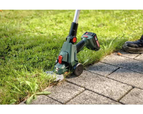 Akku-Rasenkantenschneider im Einsatz zum Schneiden von Gras an einer Pflasterfläche