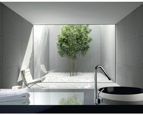 Modernes Badezimmer mit Waschbecken, Armatur und Blick auf einen Innenhof mit Bambus und weißem Kies