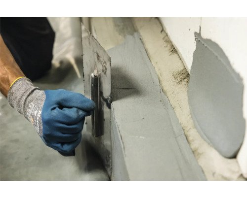 Auftragen von Dichtschlämme mit einer Glättkelle