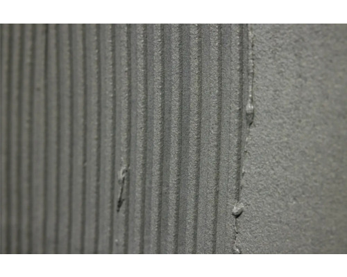 Nahaufnahme von aufgetragenem Fliesenkleber mit Kammstruktur