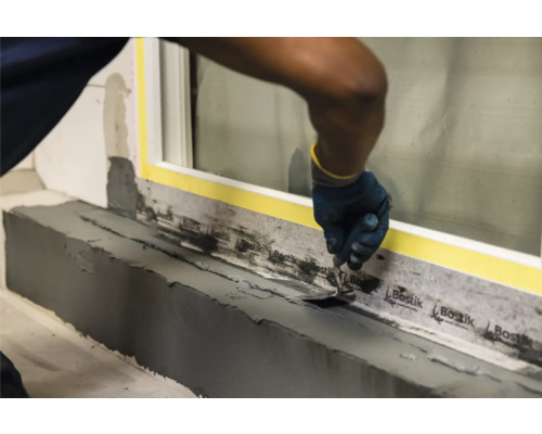 Fensterbankabdichtung mit Spachtel und Dichtband.