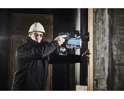 Ein Bauarbeiter mit Schutzhelm und Schutzbrille bedient einen Akku-Bohrhammer von Makita an einer Betonwand.