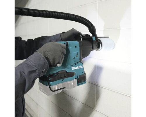 Makita Bohrhammer im Einsatz mit Staubabsaugung beim Bohren in eine Wand