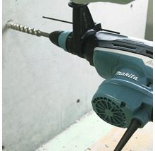 Makita Bohrhammer beim Bohren eines Lochs in eine Betonwand