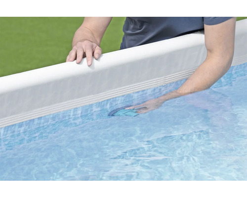 Mann reinigt Pool mit Bodenkescher