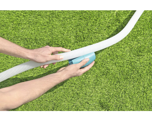 Person verbindet Schwimmbadschlauch mit Reinigungsgerät auf Rasen