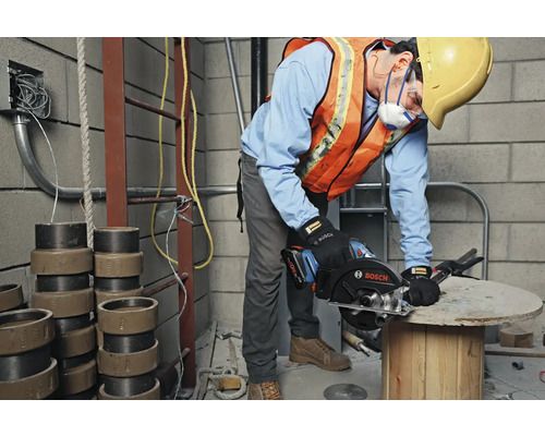 Ein Bauarbeiter benutzt eine Bosch Handkreissäge auf einer Baustelle.