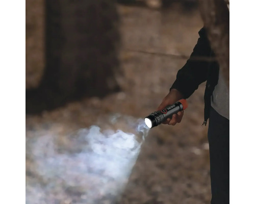 Person hält eine eingeschaltete Nebo Taschenlampe