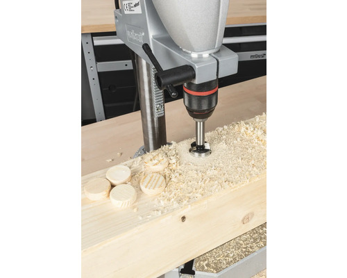 Bohrmaschine beim Bohren von Holzdübeln in ein Holzbrett