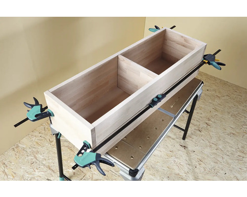 Holzkiste auf Werkbank mit Schraubzwingen fixiert