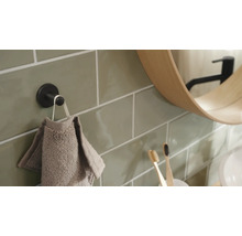 Detailansicht eines Badezimmers mit Handtuchhalter, Handtuch, Spiegel und Zahnbürsten