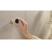 Person befestigt einen runden Wandhaken an der Wand