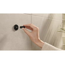 Installation einer schwarzen Bad-Garderobe an einer gefliesten Wand