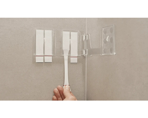 Transparenter Zahnputzbecher mit Befestigungsstreifen an einer Badezimmerwand