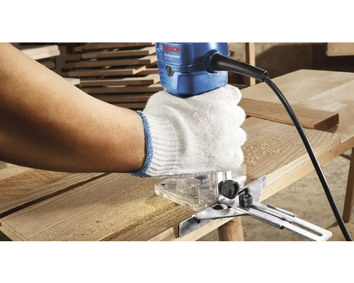 Person benutzt Oberfräse mit Handschuhen zum Bearbeiten von Holz