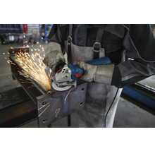 Metallbearbeitung mit einem Winkelschleifer durch eine Person mit Schutzkleidung.