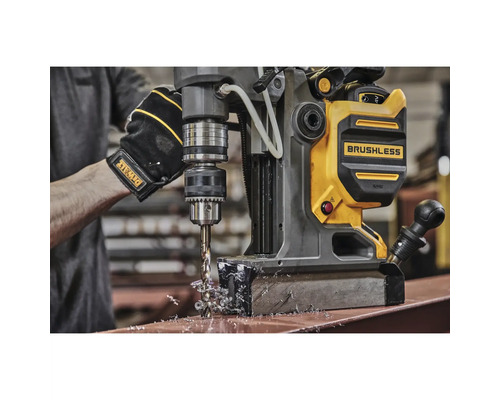 Magnetbohrmaschine beim Bohren von Metall mit Handschuhen