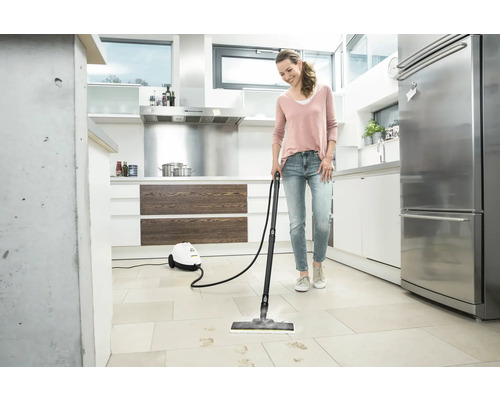 Frau reinigt Küchenboden mit Dampfreiniger
