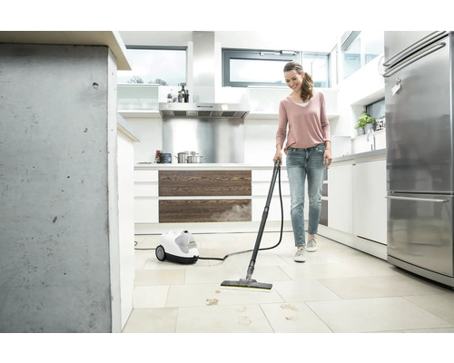 Frau reinigt Küchenboden mit einem Dampfreiniger von Kärcher