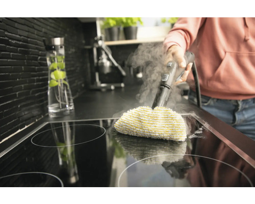 Dampfreiniger im Einsatz auf einem Kochfeld in einer Küche.