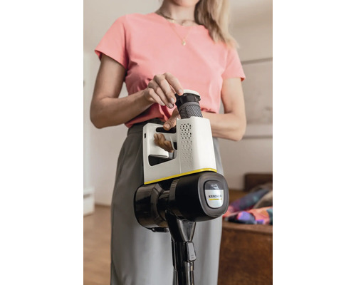 Frau bedient einen Akku Staubsauger