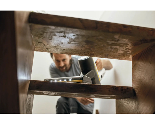 Mann reinigt Treppe mit Akku-Staubsauger mit LED-Beleuchtung