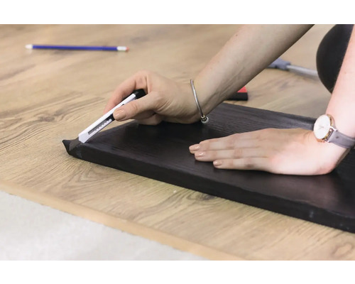 Zuschneiden einer Fussleiste mit einem Cuttermesser