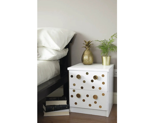 Dekoratives Schlafzimmer mit weißem Nachttisch, verziert mit Kreisen und goldenen Akzenten
