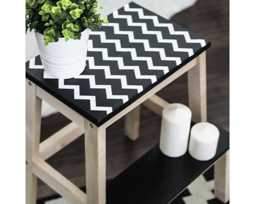 Holzhocker mit Zickzackmuster, Pflanze und Kerzen