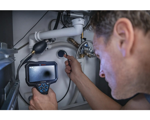 Mann verwendet eine Inspektionskamera unter einem Waschbecken zur Rohrinspektion.