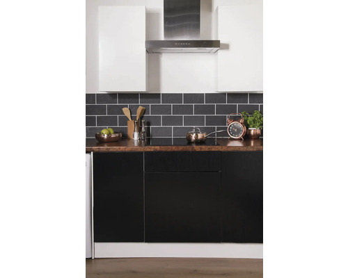 Küchenszene mit weißen Hängeschränken, Dunstabzugshaube, schwarzem Fliesenspiegel und Arbeitsplatte mit Küchenutensilien