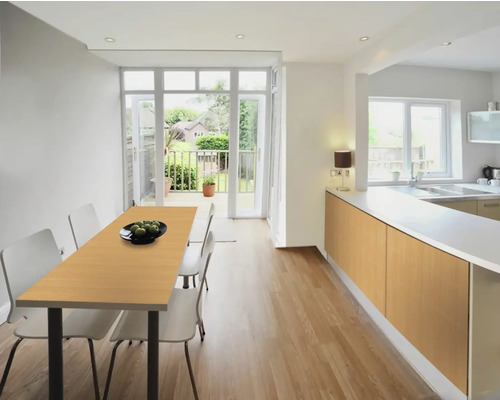 Heller Küchenraum mit Esstisch, Stühlen und Küchenzeile.