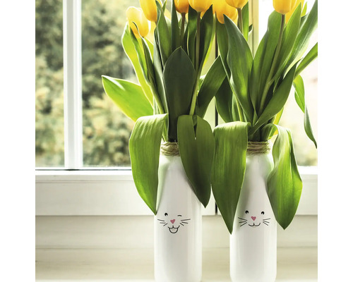 Dekorative Vasen mit Tulpen und Hasenmotiv auf einer Fensterbank